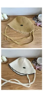 Flat lay detail of hollow-out lace straw fisherman hats with knit ties on wood table