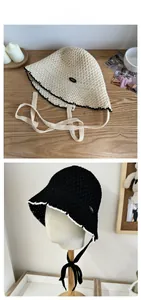 Detail of crochet straw bucket hat featuring contrast wavy edges and woven tie straps