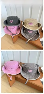 Détail du chapeau bob en denim délavé avec écusson cœur rose et cordon de serrage noir