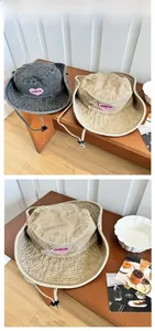 Détail d'un chapeau de soleil en denim délavé avec écusson coeur rose et mentonnière réglable
