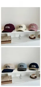 Dettaglio di cappelli da baseball vintage ricamati in vari colori su uno scaffale bianco