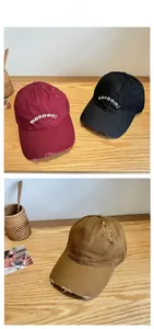 Detailed close-up of embroidered letters and distressed frayed edges on the cotton cap