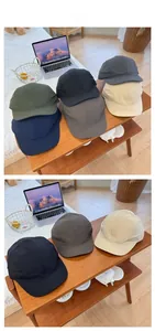 Detail of short brim quick-dry baseball caps in various colors on a wooden shelf