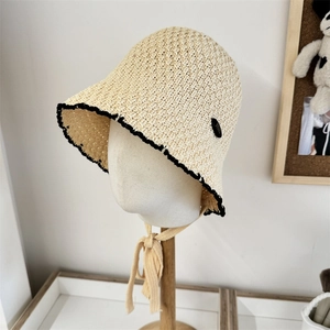 Breathable lace hollow straw bucket hat with black wavy trim and adjustable ribbon straps