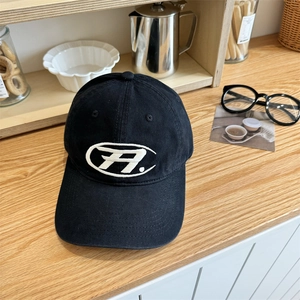 Casquette de baseball en coton noir avec logo brodé blanc sur une table en bois