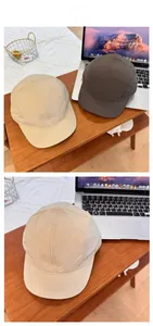 Detail view of quick-dry nylon five-panel baseball caps in beige and dark grey colorways