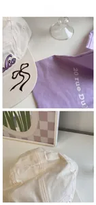 Detail of embroidered canvas baseball cap with purple ribbon trim and texture view