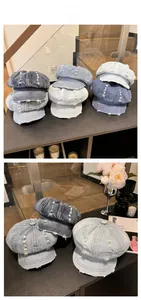 Close-up of distressed denim newsboy caps with vintage frayed edges and hole details
