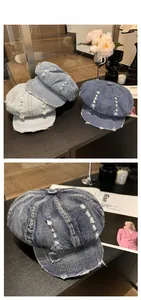 Close-up of washed denim newsboy cap with vintage distressed holes and frayed edge details