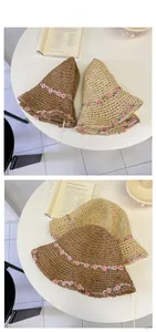Detailed close-up of straw sun hats with floral lace ribbons in beige and brown