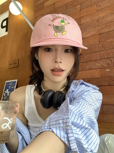 Detailed embroidery of a cartoon duck and F-ONANDOF text on a pink cotton baseball cap
