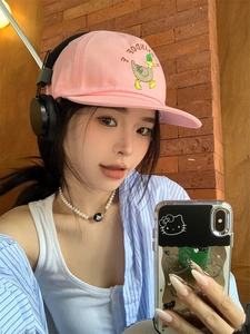 Close-up of pink cotton canvas baseball cap featuring cartoon duck embroidery and texture