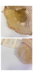 Close-up of beige straw sun hat featuring delicate pink floral embroidery and woven texture