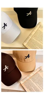 Dettaglio di cappellini da baseball in cotone in quattro colori con ricamo lettera A