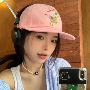 Pink cotton baseball cap with cute duck embroidery worn by a model on street background