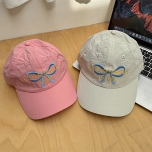 Quick-dry baseball caps with ribbon embroidery in pink and beige on wooden surface