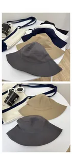Flat lay of multi-color cotton bucket hats in grey, khaki, navy, white and black colors