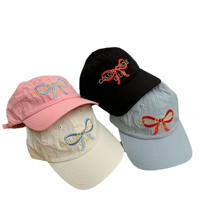 Bow embroidery baseball caps in pink, black, cream and blue showing washed fabric texture