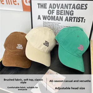 Detailed close-up of cotton baseball caps with You are Good embroidery in three colors