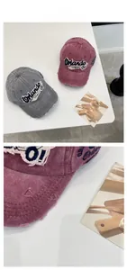 Close-up of vintage washed denim baseball caps with Orlando embroidery and distressed holes