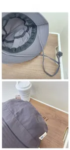 Detail of dark grey bucket hat showing quick-dry fabric texture and adjustable chin strap