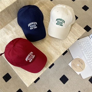 Trois casquettes Brooklyn brodées en coton de couleurs bleu marine, beige et bordeaux