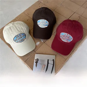 Detailed close-up of cotton baseball caps with oval Dog Person embroidery on red brick