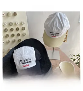 Détail de deux casquettes de baseball à cinq panneaux bicolores avec lettres brodées