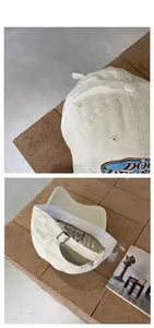 Detailed macro view of beige cotton baseball cap with blue embroidery and metal buckle