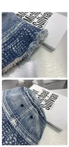 Detail of washed denim bucket hat featuring fringe edges and vintage distressed texture