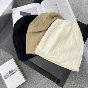 Drei weiche Strickmützen in Schwarz, Beige und Weiß mit elegantem Wellen-Texturmuster