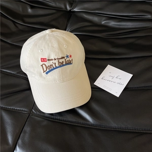 Retro cream cotton baseball cap with vintage embroidery on a black leather background