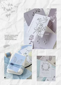 Macro shot of silver foil embossed memo cards with vintage floral and butterfly patterns
