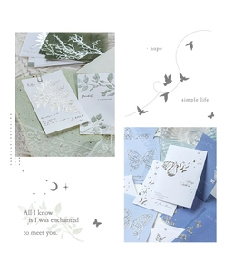Detailed view of silver foiled botanical and butterfly relief paper for scrapbooking