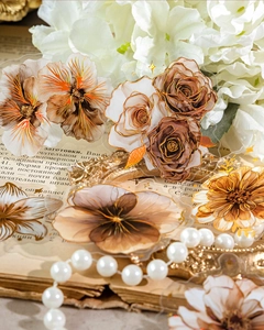 Detail of vintage PET floral stickers with gold foil accents on antique book pages