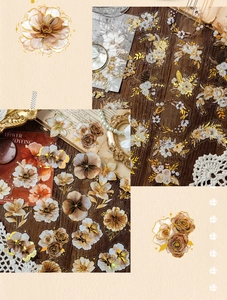 Detail of vintage flower stickers with gold stamping and PET material on dark wood background