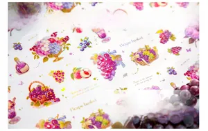 Dettaglio del nastro PET impermeabile con motivi di uva viola e cesto di fiori per scrapbooking