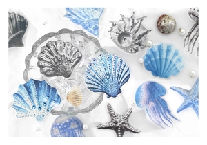 Macro shot of translucent PET ocean stickers featuring blue shells and jellyfish on white fabric