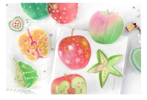 Detail of transparent fruit stickers with apple designs and glittering star textures
