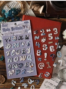 Primer plano de pegatinas de alfabeto vintage con motivos florales azules para scrapbooking