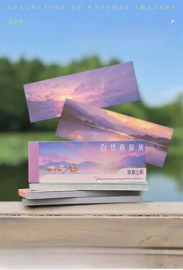 Detailed view of nature-themed sticker sheets with purple landscapes on wooden background