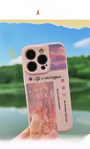 Pink matte phone case with sunset cloud stickers and life quote held near a lake