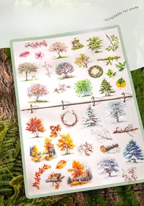 Macro shot of seasonal tree stickers with watercolor art for DIY scrapbooking decoration