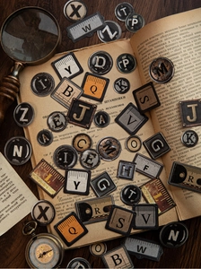 Macro detail of vintage alphabet stickers with antique clock and magnifying glass props