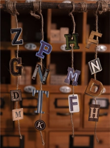 Macro view of vintage alphabet sticker pack with diverse textures like leather and denim