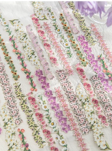 Dettaglio di adesivi floreali per scrapbooking con disegni di margherite e tulipani