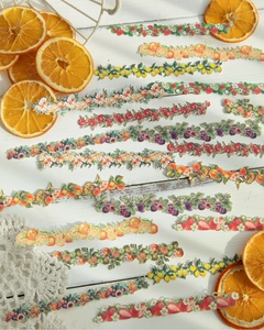 Dettaglio di adesivi decorativi con fiori e frutta su fondo di legno bianco