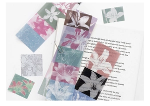 Macro detail of translucent floral lily PET stickers on vintage book background