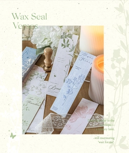 Detail of vintage floral embossed bookmarks with wax seal stamp on a wooden table