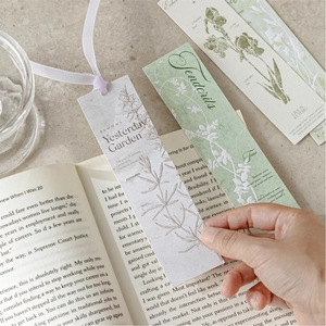 Embossed floral bookmark set Yesterday Garden displayed on an open book in use